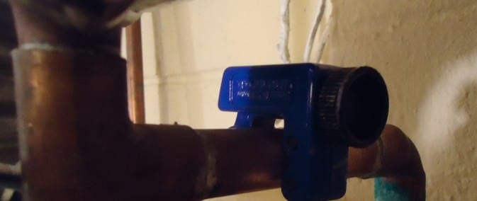 Tube cutter positioned around copper pipe, representative task detail
